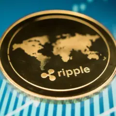 Goldene Ripple-Münze mit Weltkarte und dem XRP-Logo auf einem blauen Hintergrund mit steigenden Diagrammen, die eine positive XRP-Prognose andeuten.