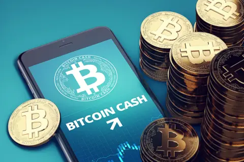 Smartphone zeigt Bitcoin Cash, daneben stapeln sich goldene Bitcoin Cash Münzen.