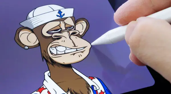 Ein digitaler Künstler bearbeitet einen **nft bored ape** mit einem Stift auf einem Tablet. Der Affe trägt eine Matrosenmütze und ein Hemd mit Sternen.