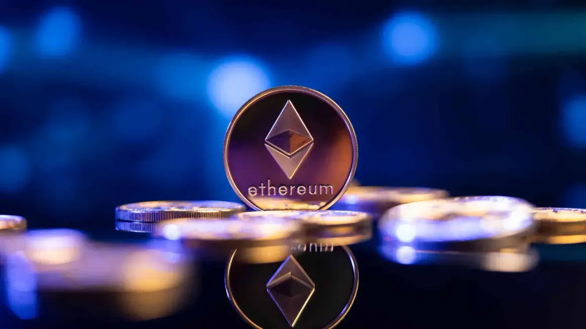 Eine glänzende Ethereum-Münze, die das Symbol und den Namen trägt, steht im Fokus. Sie ist Teil einer Ansammlung von Münzen, die auf einer dunklen, spiegelnden Oberfläche liegen und die Zukunft von eth 2.0 symbolisieren.